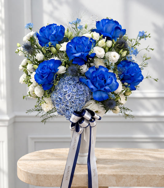 Luxurious blue rose and white lisianthus vase arrangement with hydrangea and thistle, tied