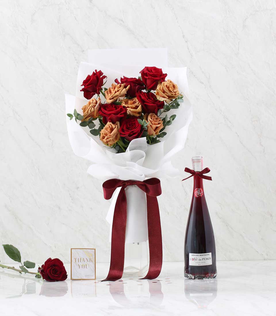 Luxury red and peach rose bouquet with Ecuadorian roses, green eucalyptus, and premium red wine gift set for anniversaries