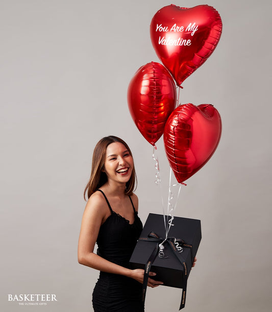 Luxury black gift box with red heart balloons and romantic message for Valentine's Day