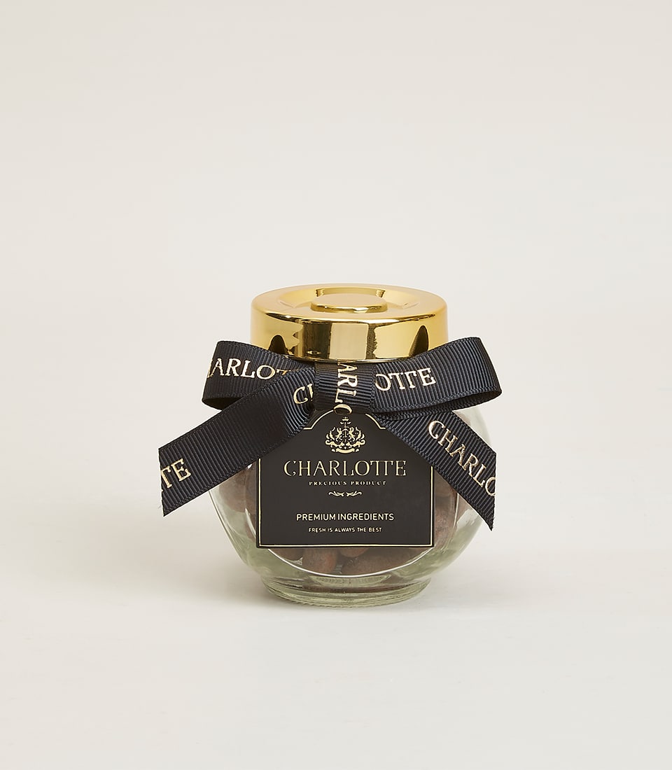 Caramelized pistachios in dark chocolate, Charlotte Bakery artisan confection in glass jar with gold lid