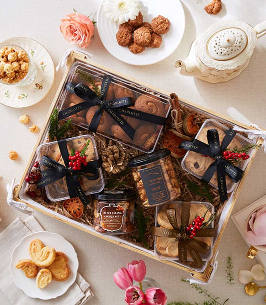 Gourmet mixed cookies gift box with chocolate, nuts, and caramel treats in elegant ribbon-tied packaging