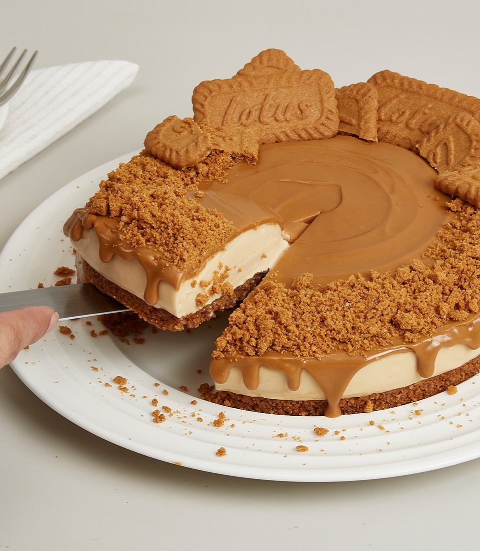Creamy Lotus Biscoff cheesecake with caramel drip and crushed biscuit crust, sliced and served