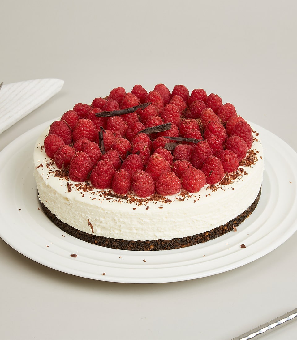 Raspberry cream cheesecake with chocolate shavings on white ceramic plate