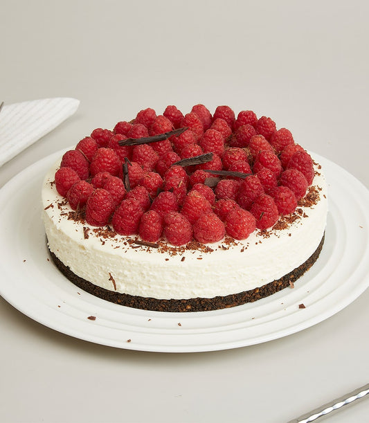 Raspberry cream cheesecake with chocolate shavings on white ceramic plate