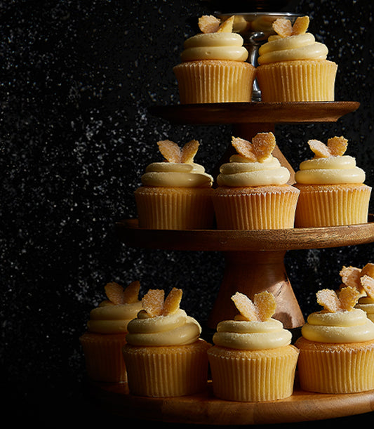 Christmas vanilla butter cream cupcakes with candied ginger on tiered wooden stand