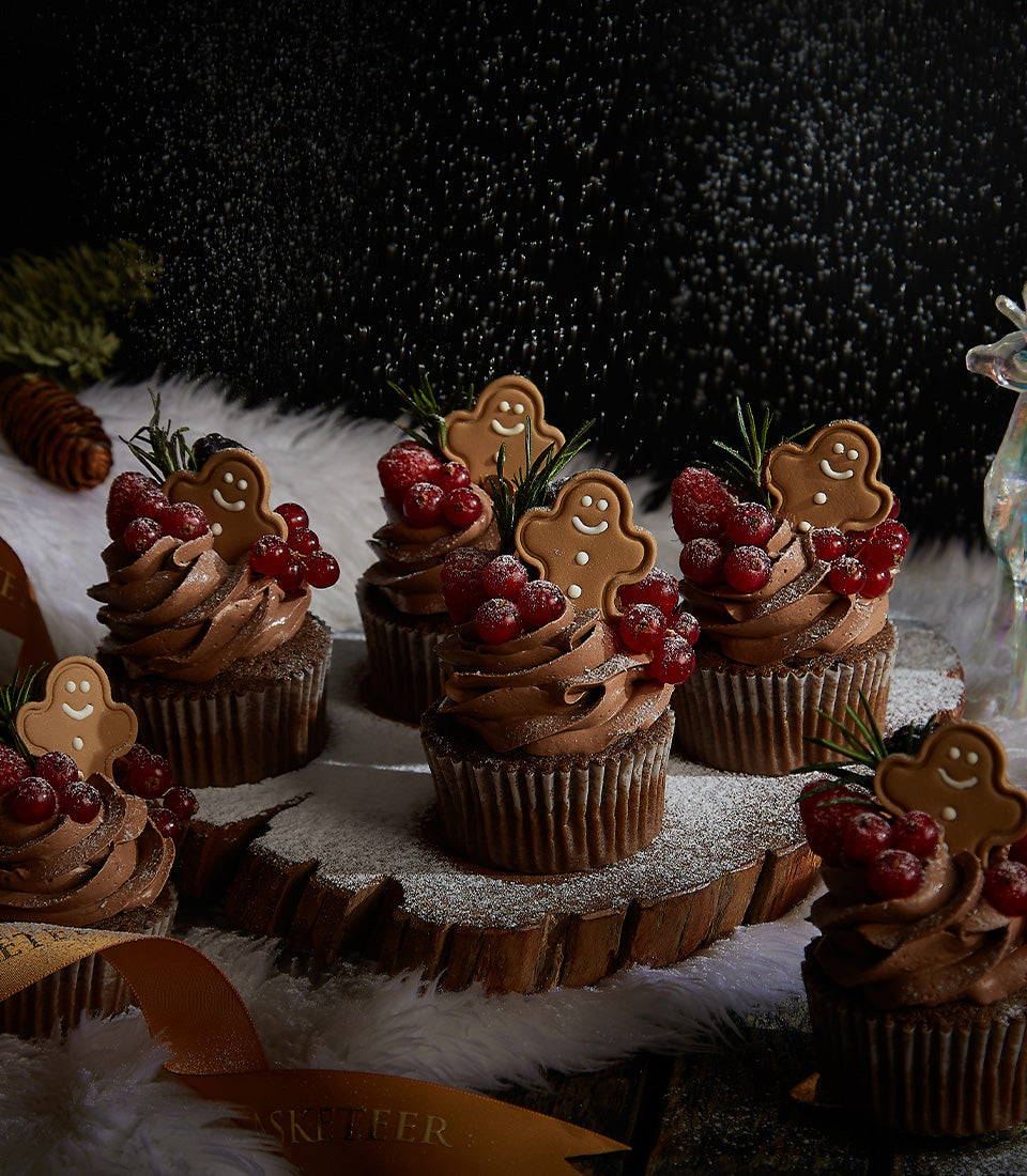 Chocolate ganache gingerbread man cupcakes with fresh berries and rosemary, festive Christmas gift collection