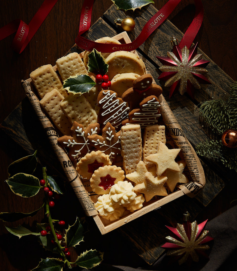 Festive Christmas cookie assortment with gingerbread, shortbread, and jam-filled rounds in wooden gift tray