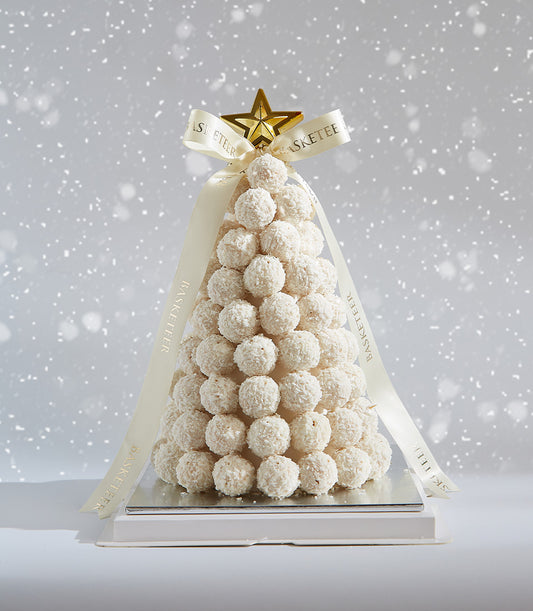 Ferrero Raffaello white truffle Christmas tree with coconut coating, golden star topper, and cream ribbon on silver base