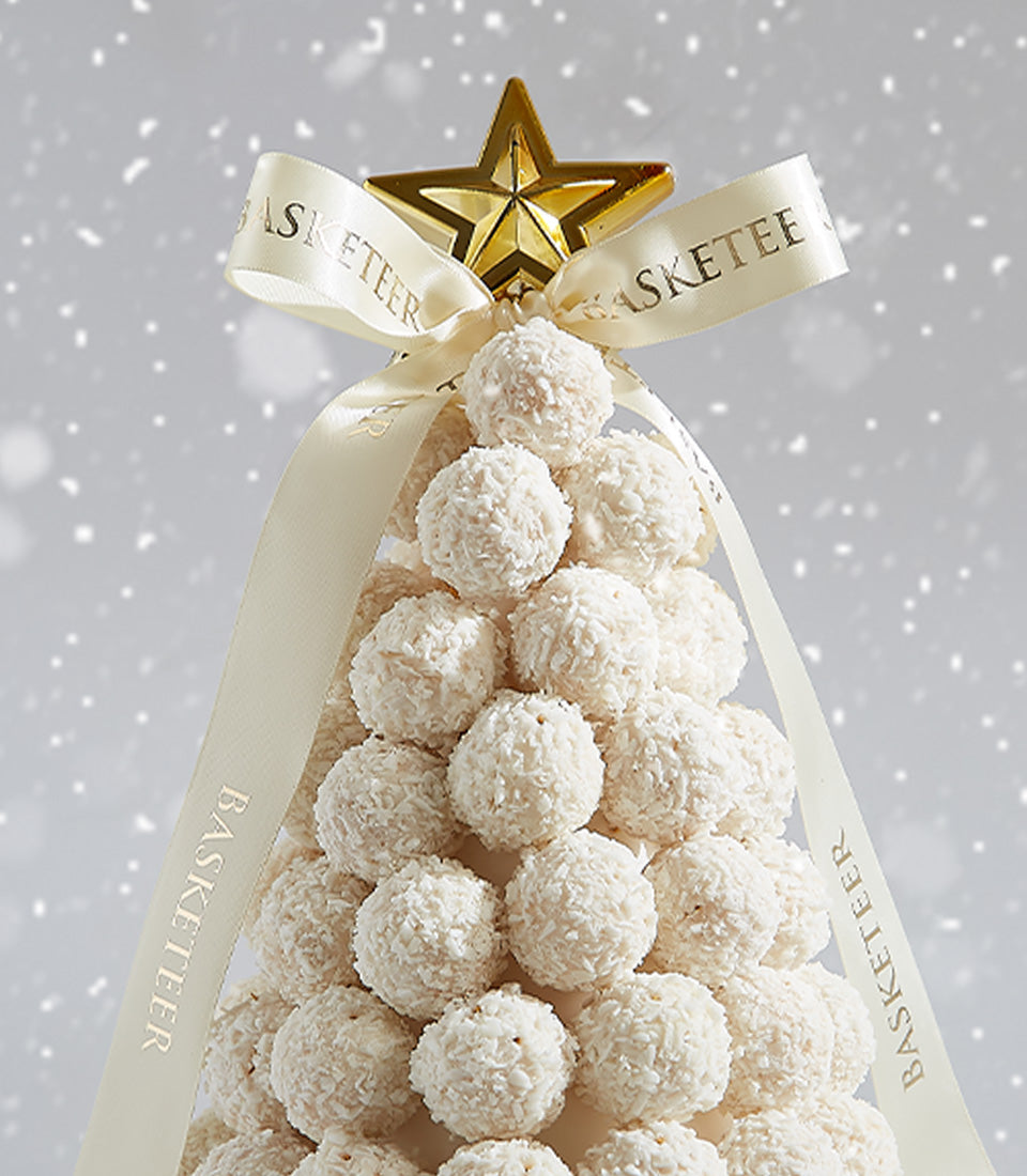 Festive Christmas tree arrangement of white Ferrero Raffaello coconut confections with cream ribbon and golden star topper