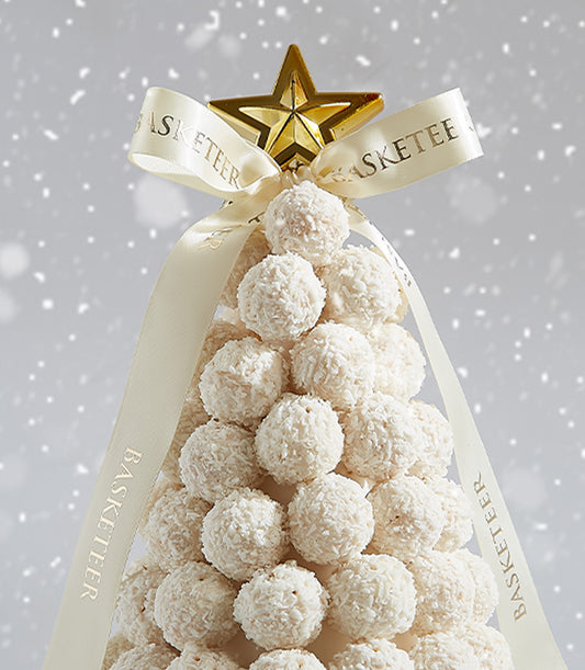 Festive Christmas tree arrangement of white Ferrero Raffaello coconut confections with cream ribbon and golden star topper