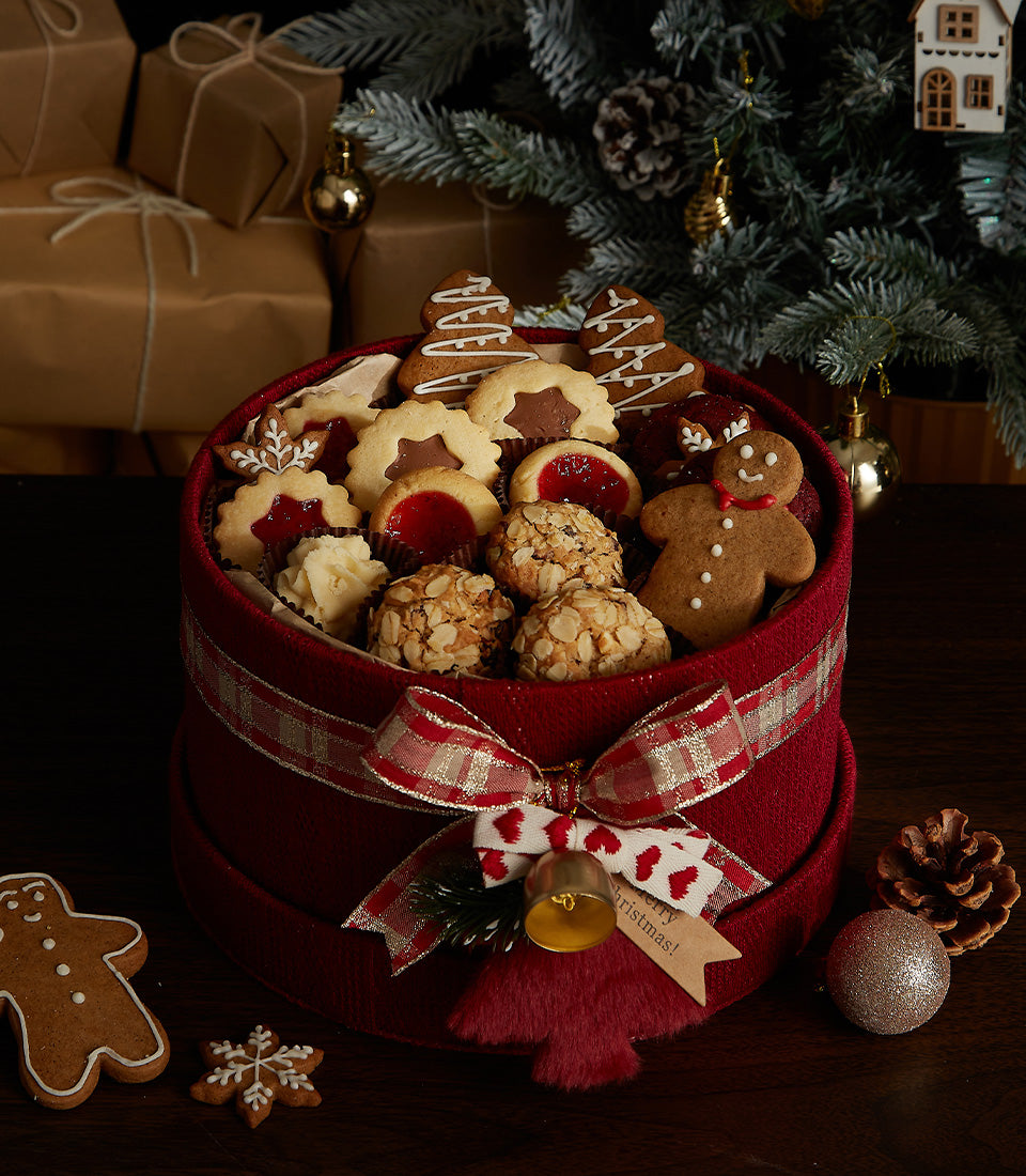 Festive red holiday cookie gift box with gingerbread, jam-filled and snowflake cookies, plaid ribbon bow