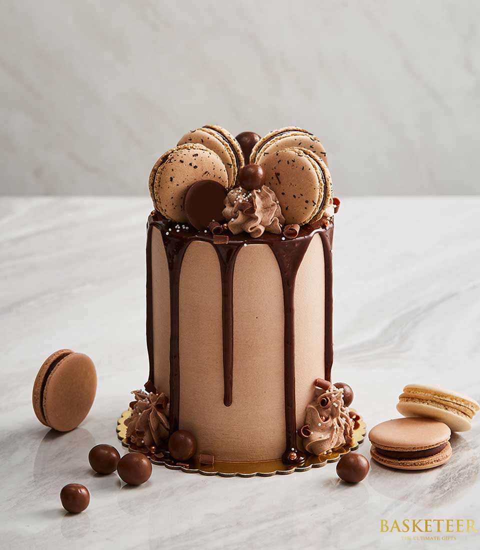 Chocolate macaron drip cake with ganache, chocolate spheres, and piped frosting for birthdays