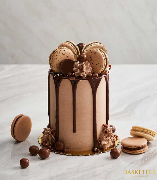 Chocolate macaron drip cake with ganache, chocolate spheres, and piped frosting for birthdays