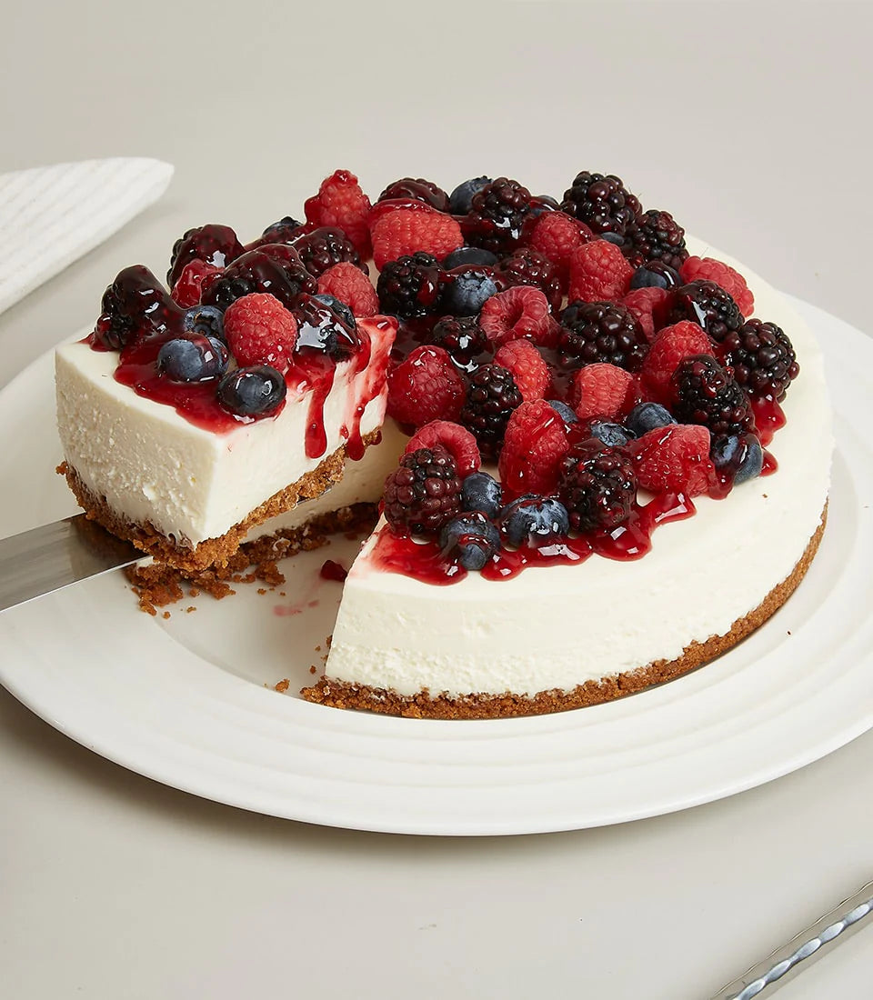 Charlotte Bakery's artisan round cheesecake, richly topped with fresh raspberries, blueberries