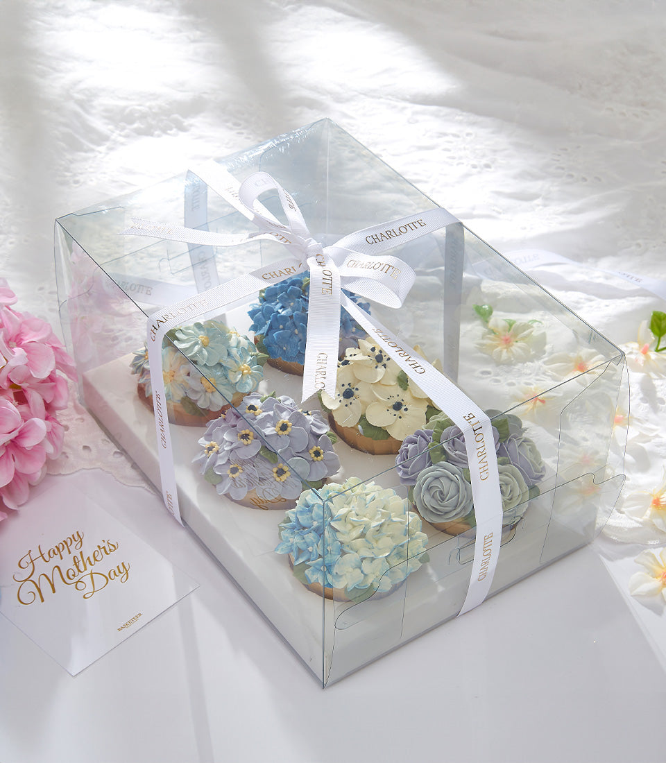 Pastel floral cupcakes in gift box with hydrangeas, pansies, and roses for Mother's Day