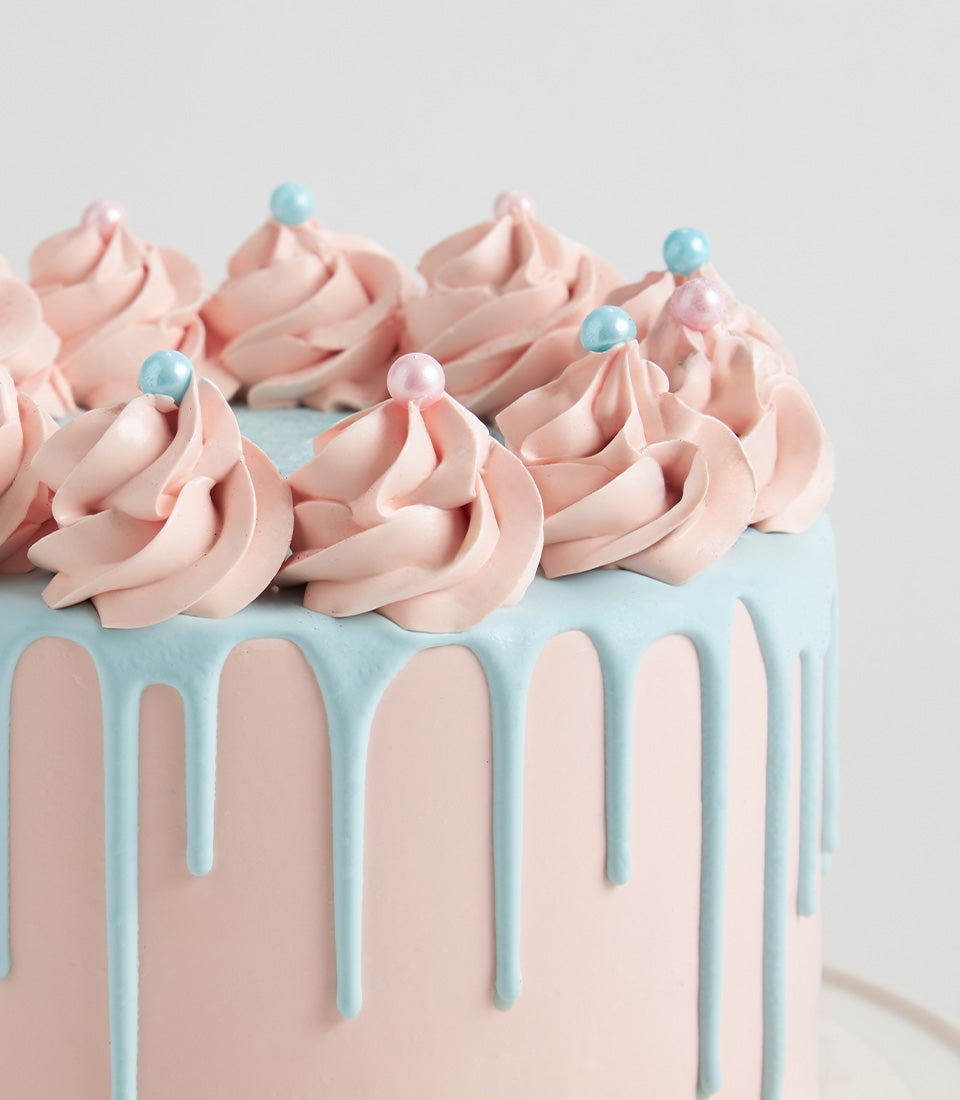 Pastel pink and blue layer cake with pearl sprinkles, perfect for birthdays