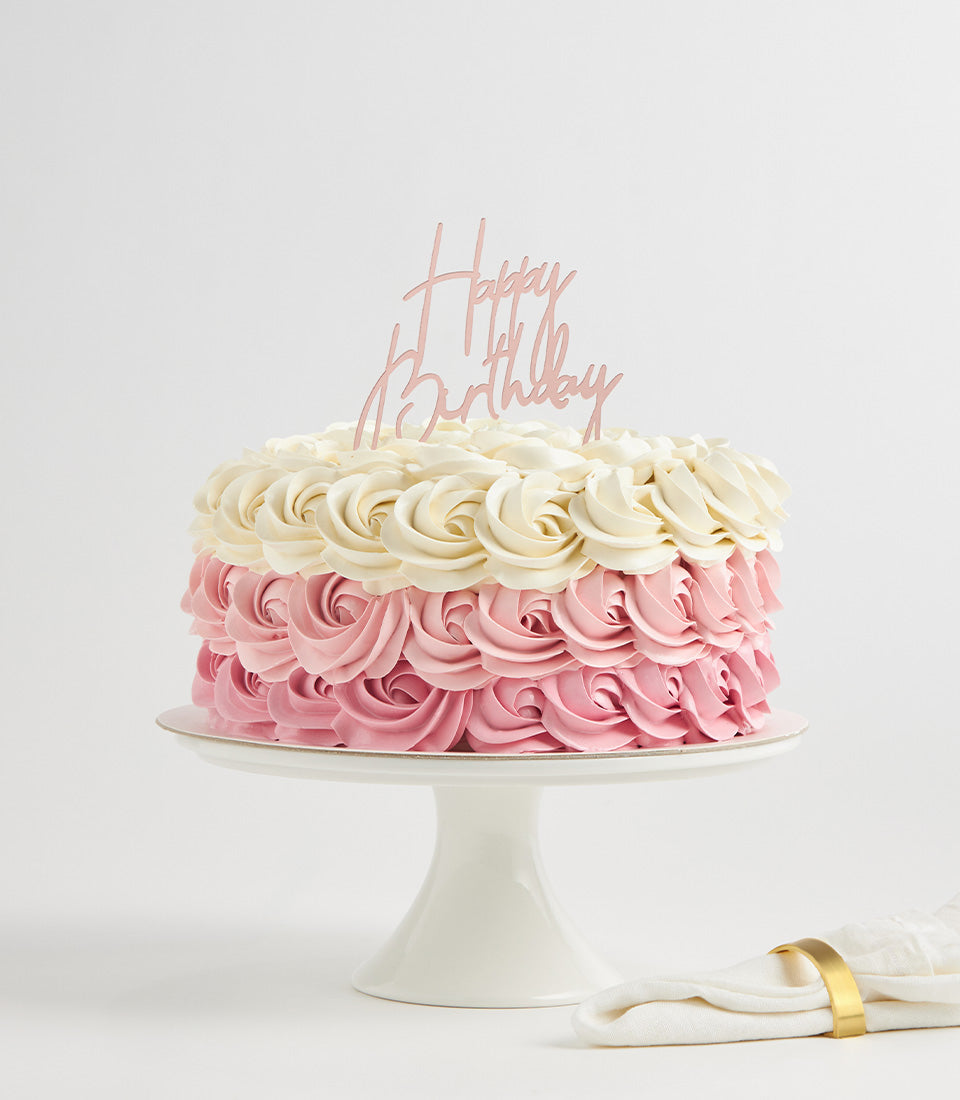 Charlotte Bakery custom cake Bangkok: Round buttercream birthday cake, frosted with pink and white rosettes and a "Happy Birthday" topper.