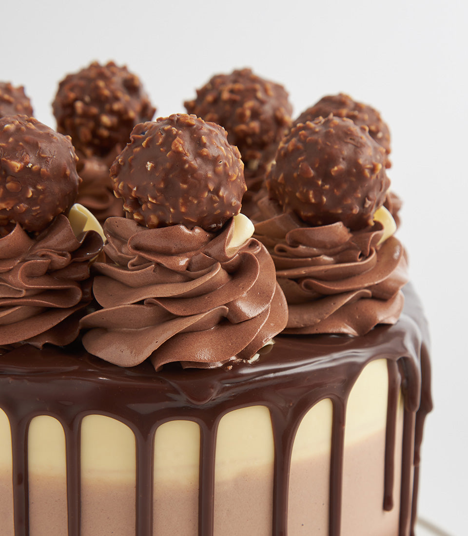 Triple-layer chocolate Ferrero Biscoff cake with ganache drip and hazelnut chocolates, birthday celebration dessert