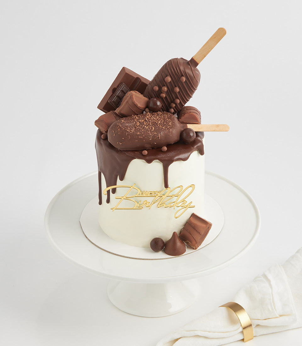 Luxe chocolate drip birthday cake topped with chocolate bars and truffles, gold Happy Birthday topper