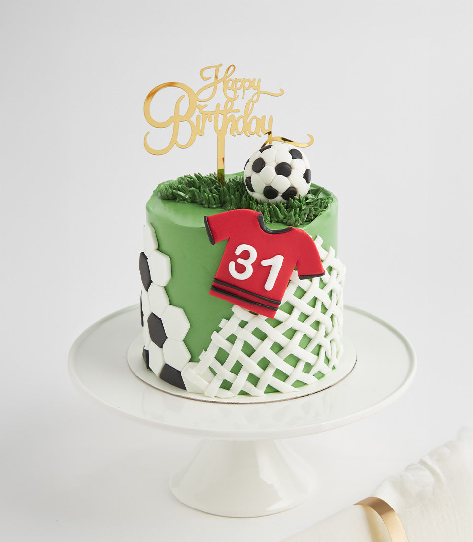 Green grass fondant football field cake with soccer ball, jersey number, and gold Happy Birthday topper