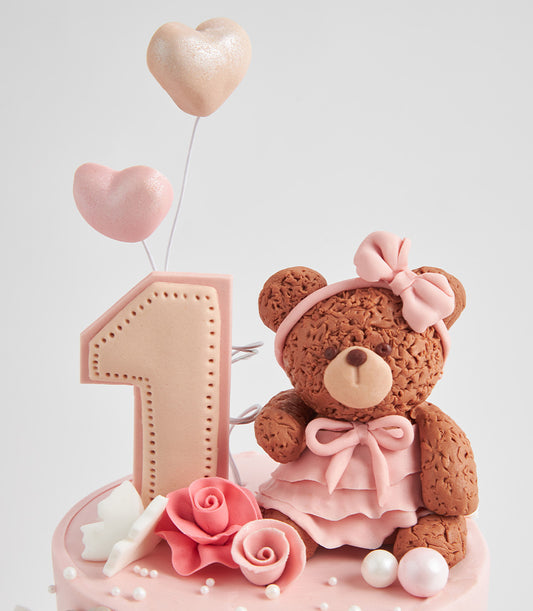 Sweet bear first birthday cake with pink fondant roses, butterfly, and heart balloons