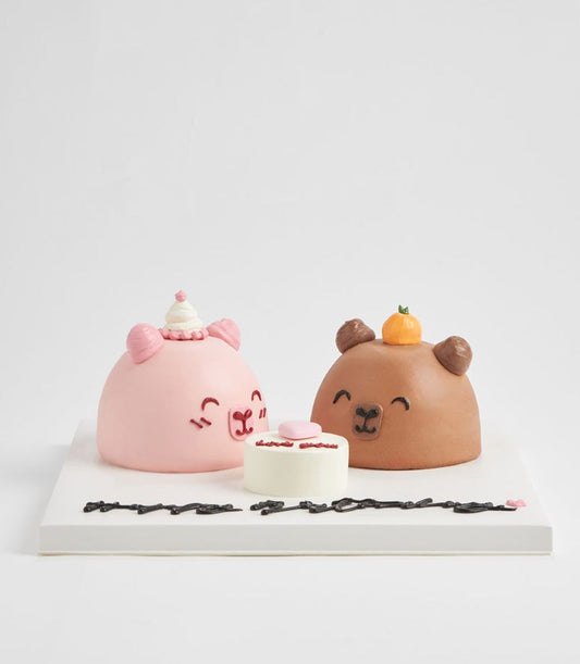Charming character-themed mini cakes in pink and brown with simple faces, perfect for kids' celebrations from Charlotte