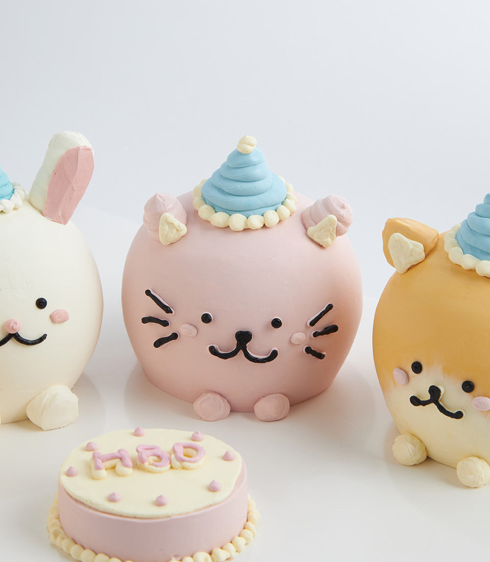 Adorable mini animal birthday cakes with cat, rabbit, and dog designs in pink, white, and cream frosting