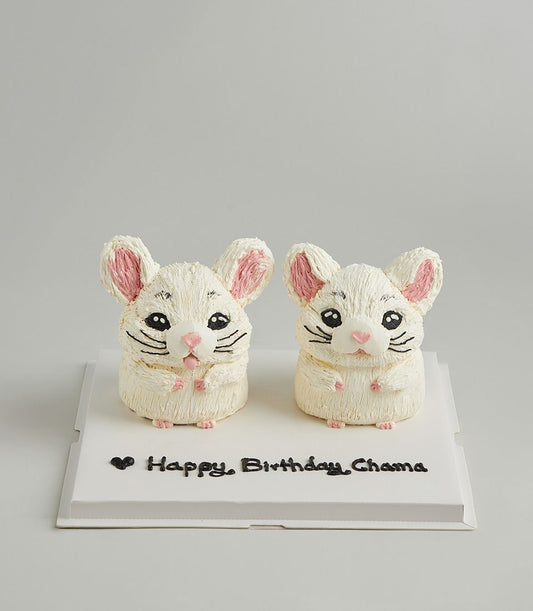 Twin white chinchilla buttercream cakes with pink ears and noses for birthday celebration