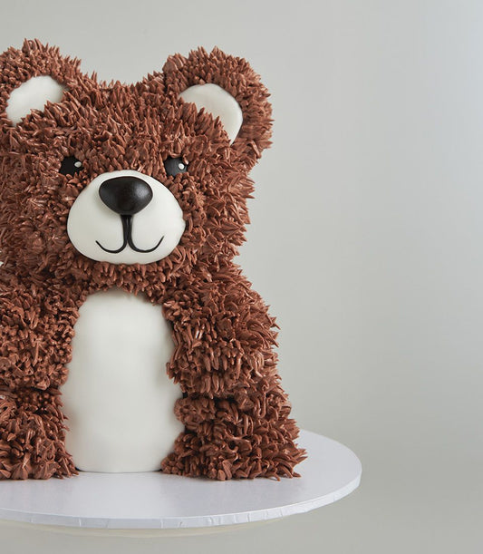 Brown teddy bear cake with white muzzle and textured frosting, artisan celebration cake for kids