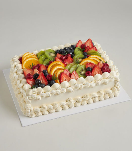 Rectangular fresh fruit celebration cake with cream frosting, strawberry, kiwi, blueberry and orange topping from Charlotte