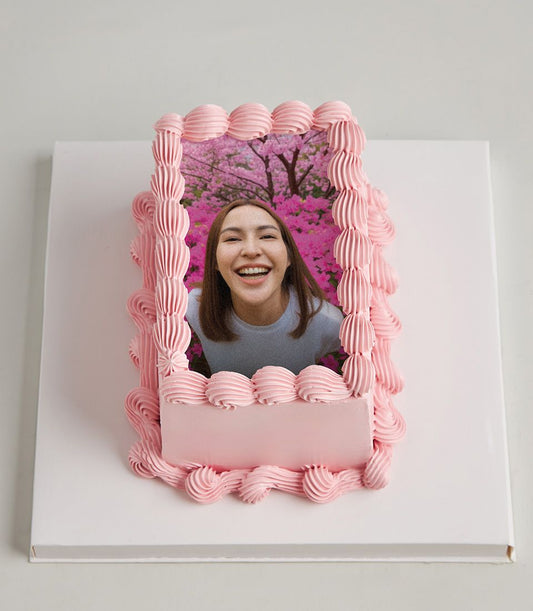 Pink buttercream layer cake with custom edible photo print and decorative piped border