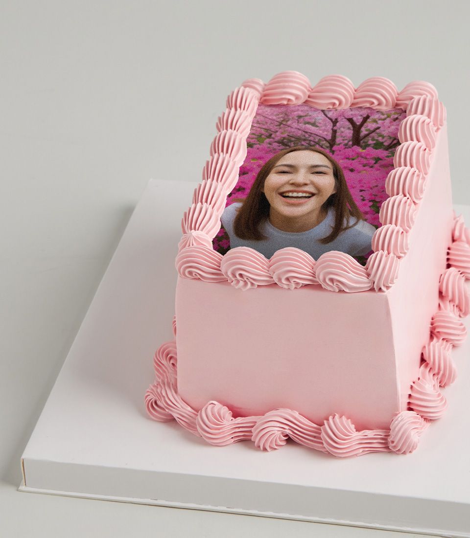 Pink buttercream layer cake with custom edible photo and decorative piping
