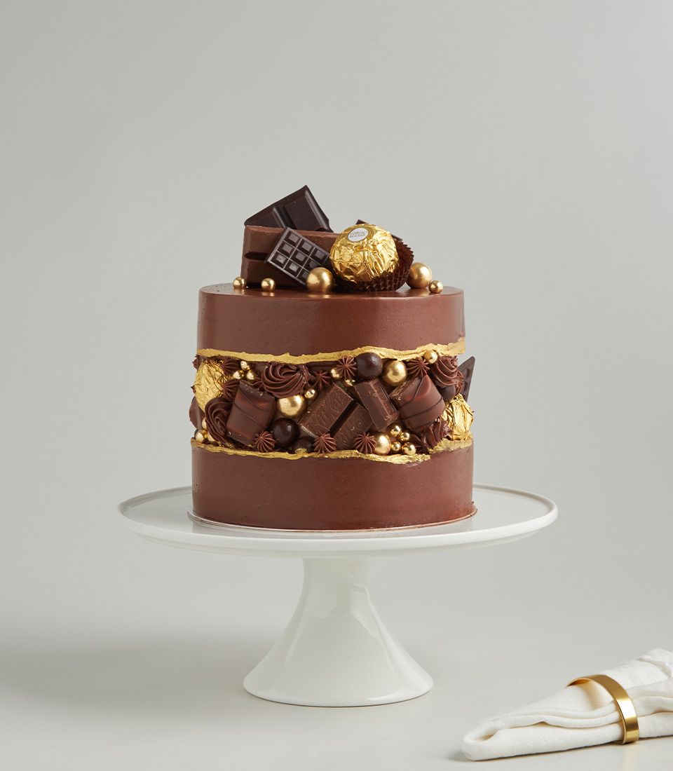 Luxury two-tiered chocolate ganache cake with Ferrero Rocher, gold leaf details, and artisan truffles