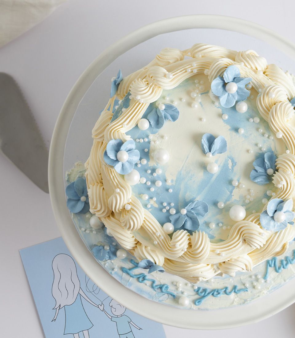Elegant blue and white marbled Mother's Day cake with sugar pearls and fondant flowers, "Love you Mom" inscription