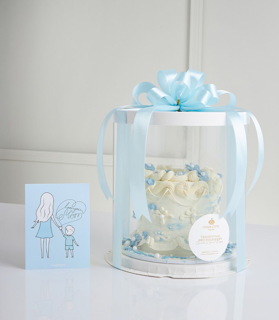 Elegant two-tier vanilla cake with white frosting, blue flowers and pearls, paired with Mother's Day greeting card