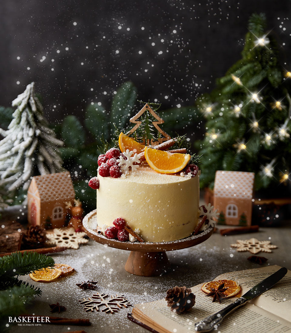 Winter Wonderland orange cake with raspberry, orange slice, and cinnamon stick toppings on festive holiday display