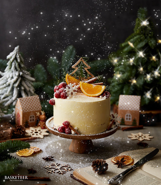 Winter Wonderland orange cake with raspberry, orange slice, and cinnamon stick toppings on festive holiday display