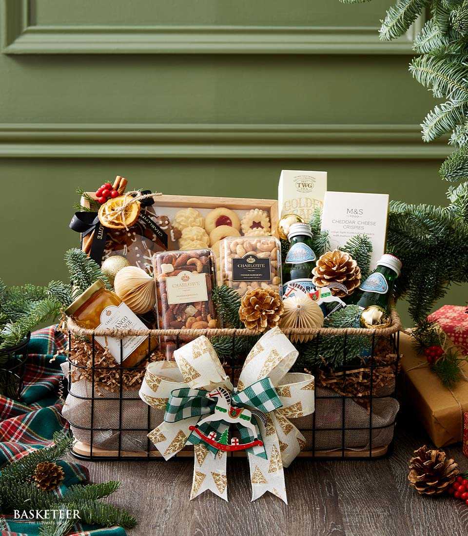 Festive Christmas gift basket with gourmet cookies, nuts, jam, tea, and crackers tied with gold ribbon