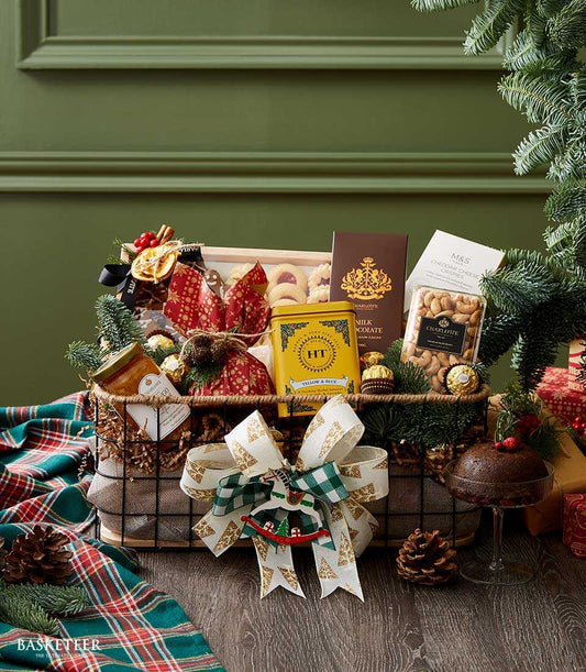 Festive Christmas gift basket with gourmet treats, dark wire design, white and gold ribbon, chocolate, cheese crisps, and