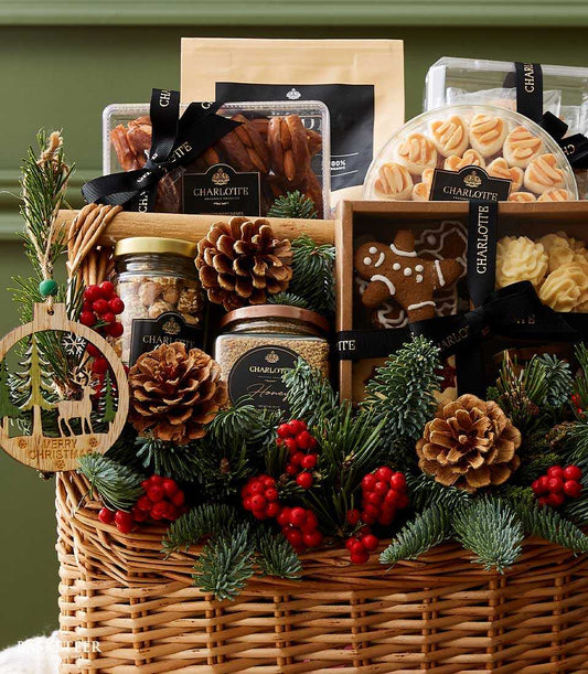 Woven wicker Christmas desserts gift basket with gourmet treats, cookies, nuts, and festive pine decorations