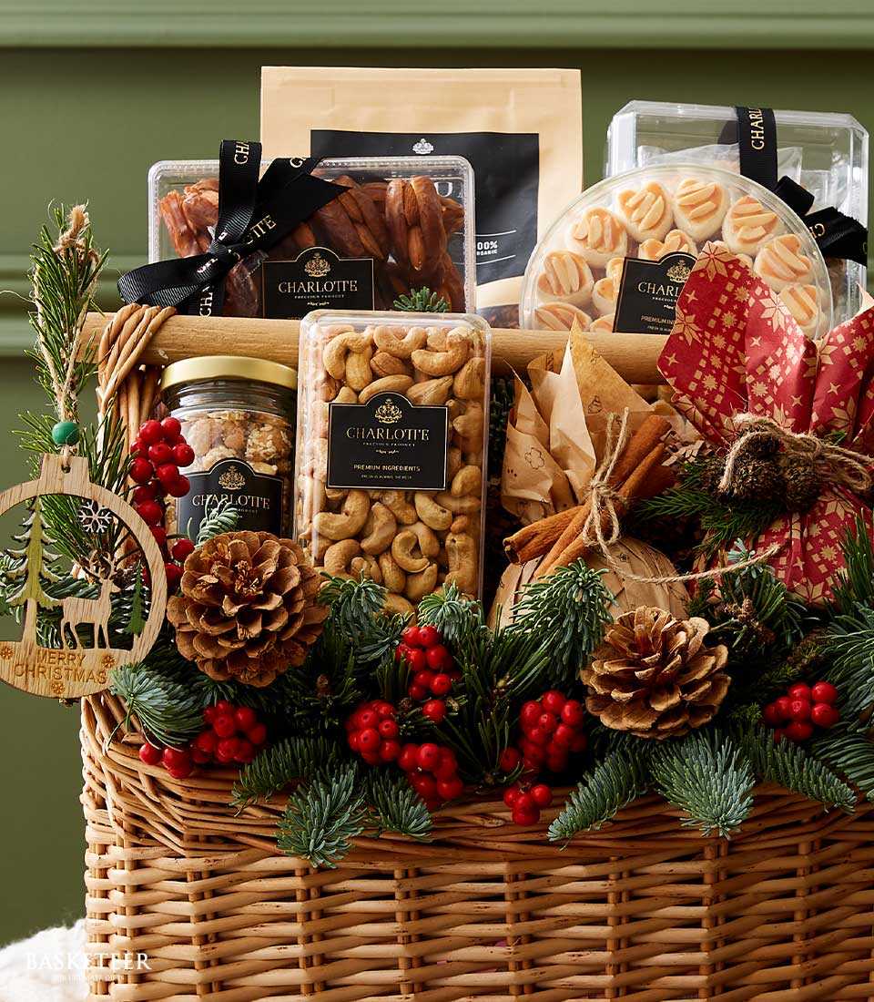 Wicker Christmas hamper with Charlotte gourmet treats, dried dates, cashews, pastries, pine branches, red berries, and
