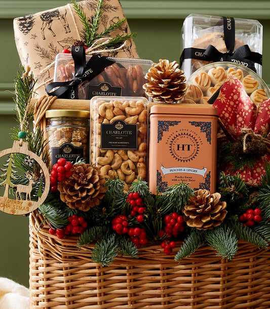 Festive Christmas wicker hamper with gourmet sweets, premium tea, and holiday greenery