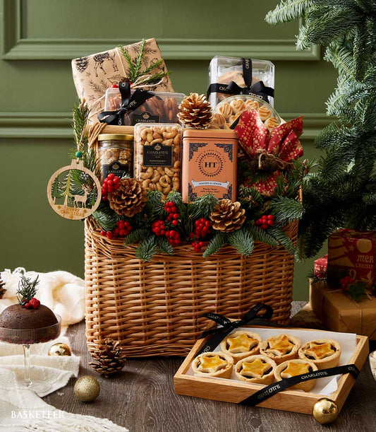 Festive Christmas gift basket with gourmet treats, nuts, tea, cookies, mince pies, and seasonal decorations