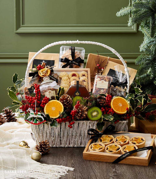 Luxury white wicker hamper filled with gourmet Christmas treats, honey, cookies, and festive decorations