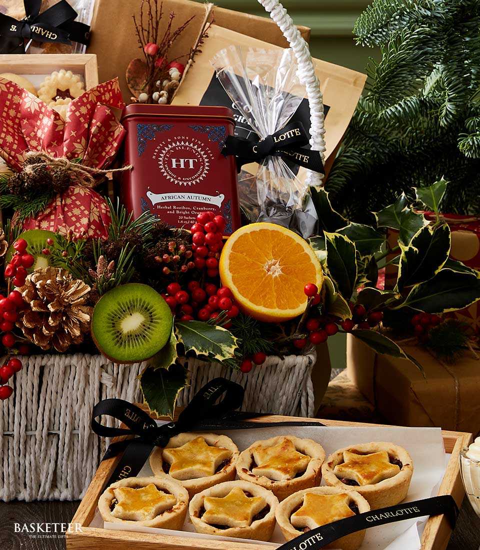 Festive Christmas gift basket with rooibos tea tin, mince pies, dried citrus, and seasonal greenery