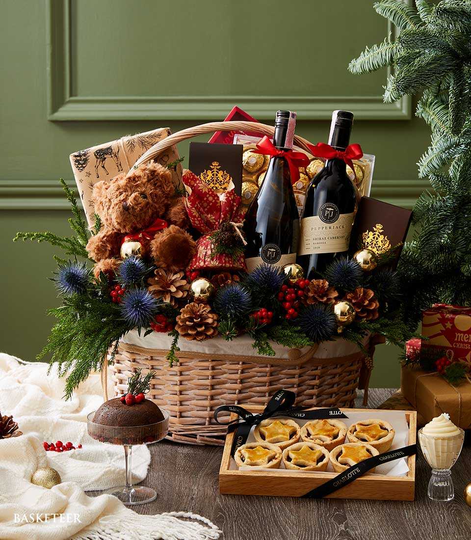 Festive Christmas wine gift basket with Pepperjack Shiraz, chocolates, teddy bear, and seasonal florals