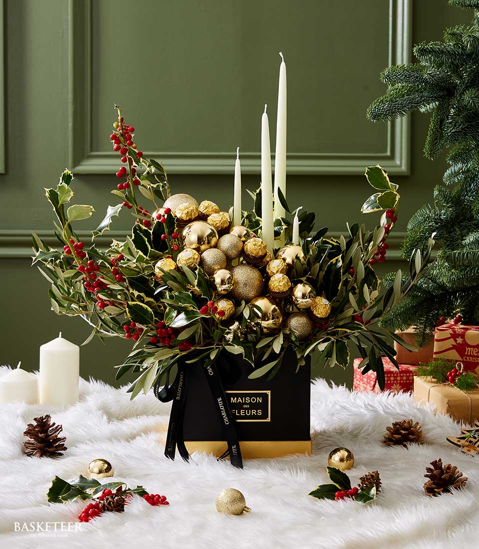 Luxury Christmas candle centerpiece with holly, gold ornaments, and Ferrero Rocher in black gift box
