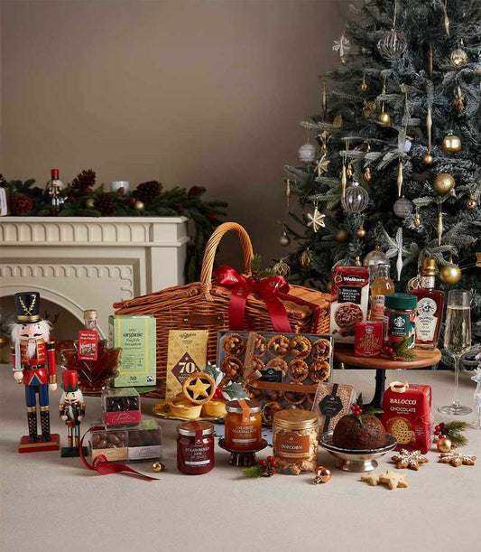 Grand Christmas hamper with gourmet treats, jams, biscuits, and festive baked goods on wicker basket