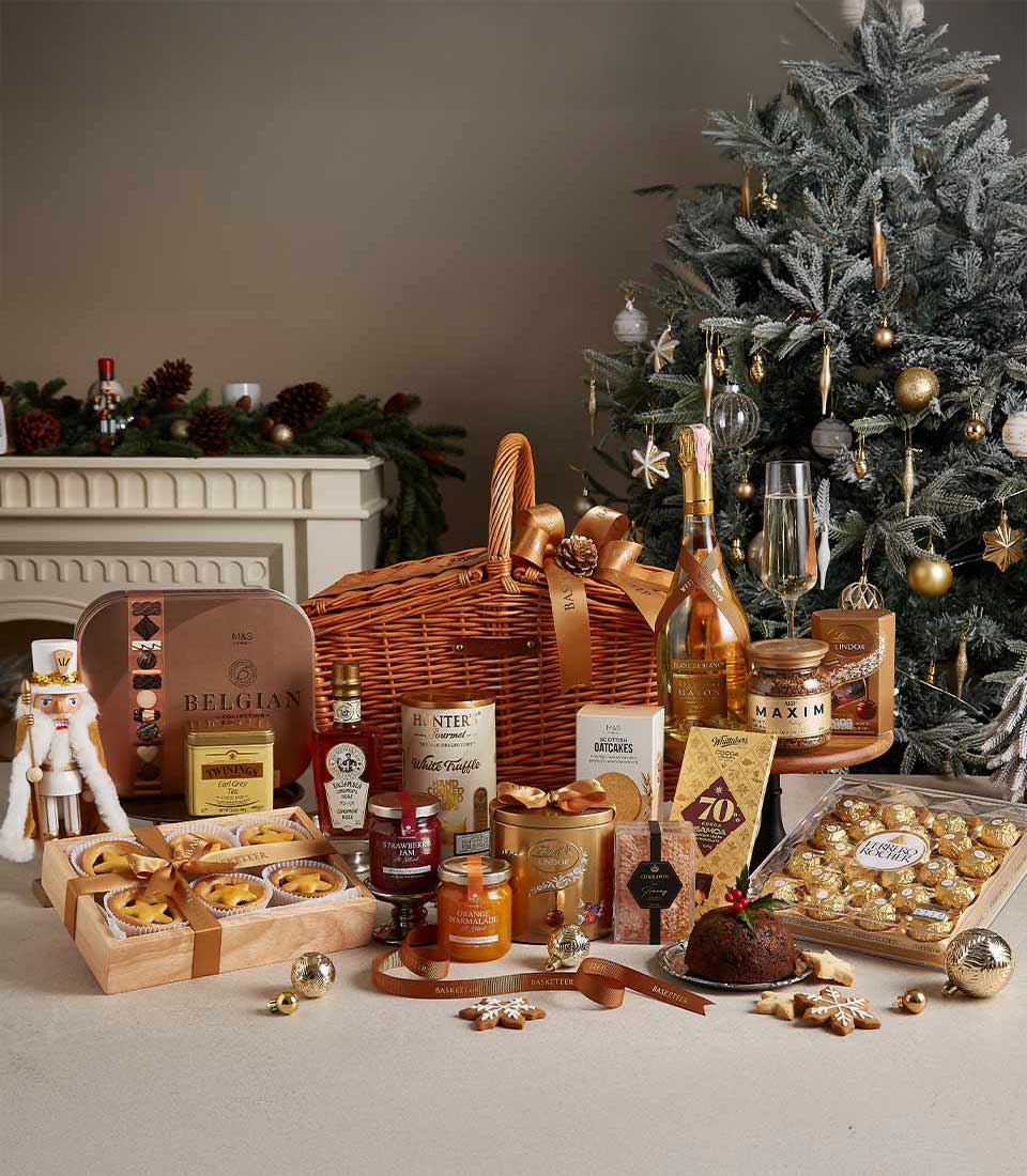 Luxurious Christmas hamper with champagne, gourmet chocolates, preserves, and festive treats in wicker basket