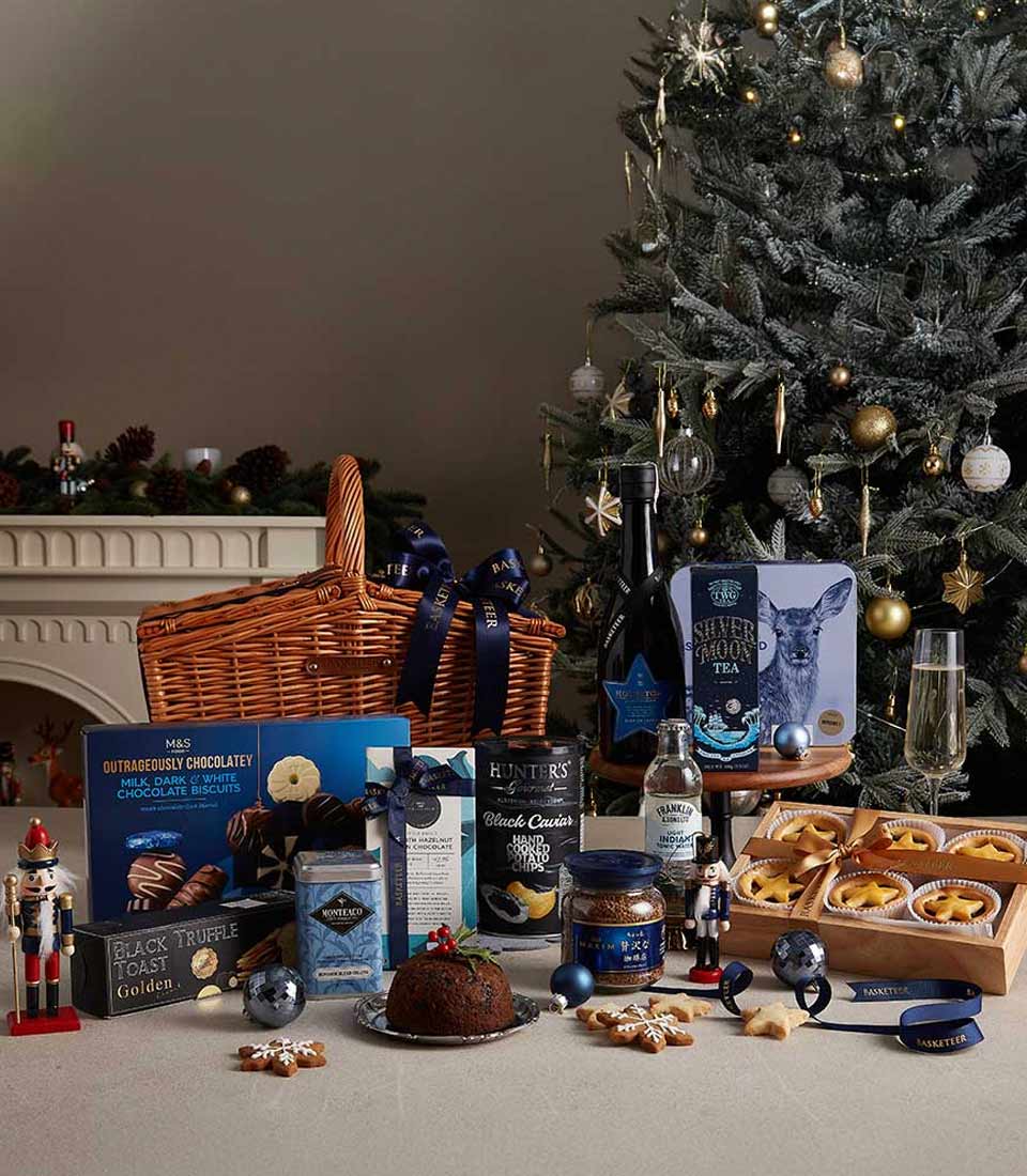 Luxury midnight Christmas hamper with gourmet chocolates, red wine, premium teas, and festive treats in wicker basket